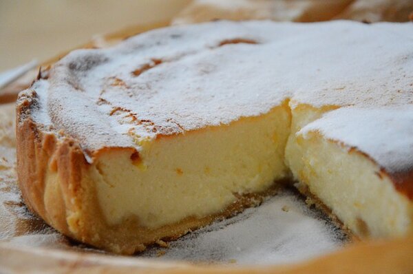 Cheesecake, white top, one slice out at front