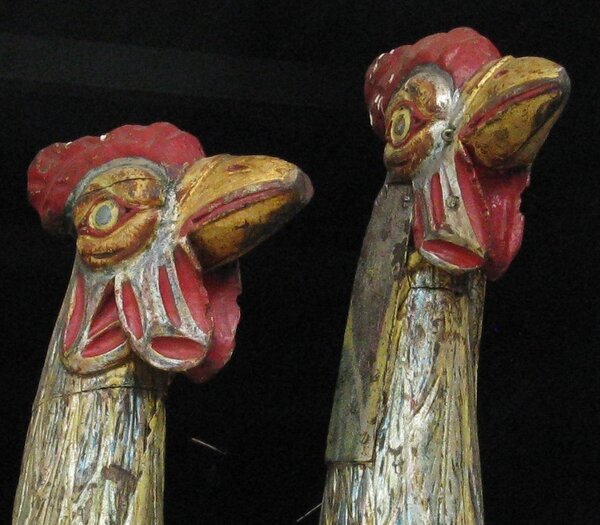 Photo (c) .G. Betts. Two giant wooden chicken heads facing right. 