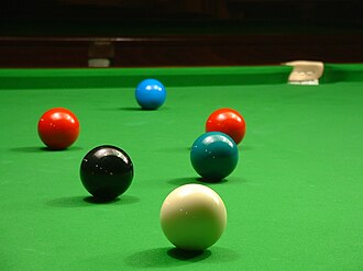 Blue, red, black, white snooker balls on green baize.