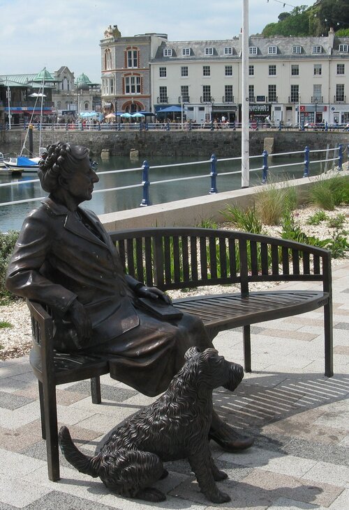 Bronze by Toquay harbour of Agatha Christie on bench with her dog Peter looking rightench peter looking right